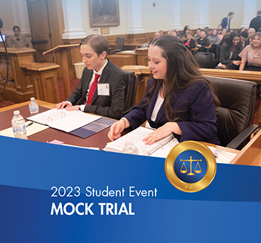 2023 Student Events. Mock Trial.Student lawyers reviewing notes in court room.