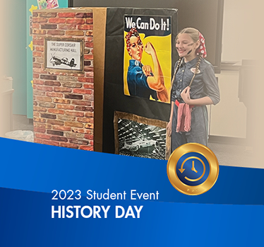 Student dressed like Rosie the Riveter standing by the icon poster of her during a History Day performance. 2023 Student Events History Day