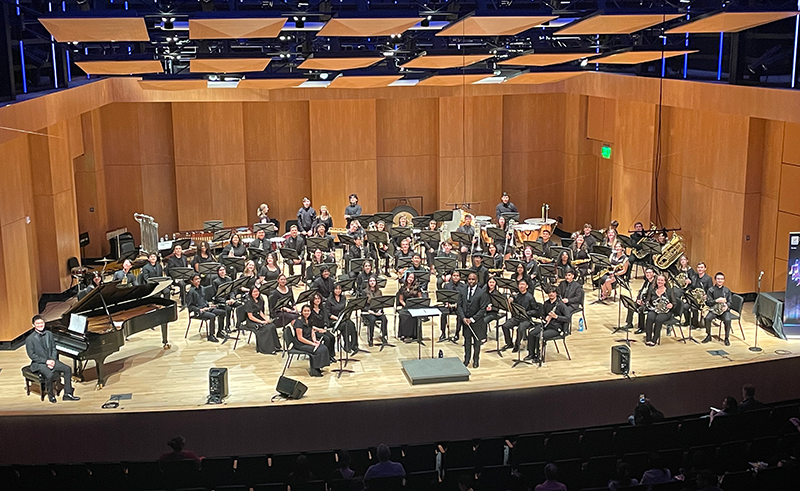 View of students seated for an orchestra performance on modern performing arts stage