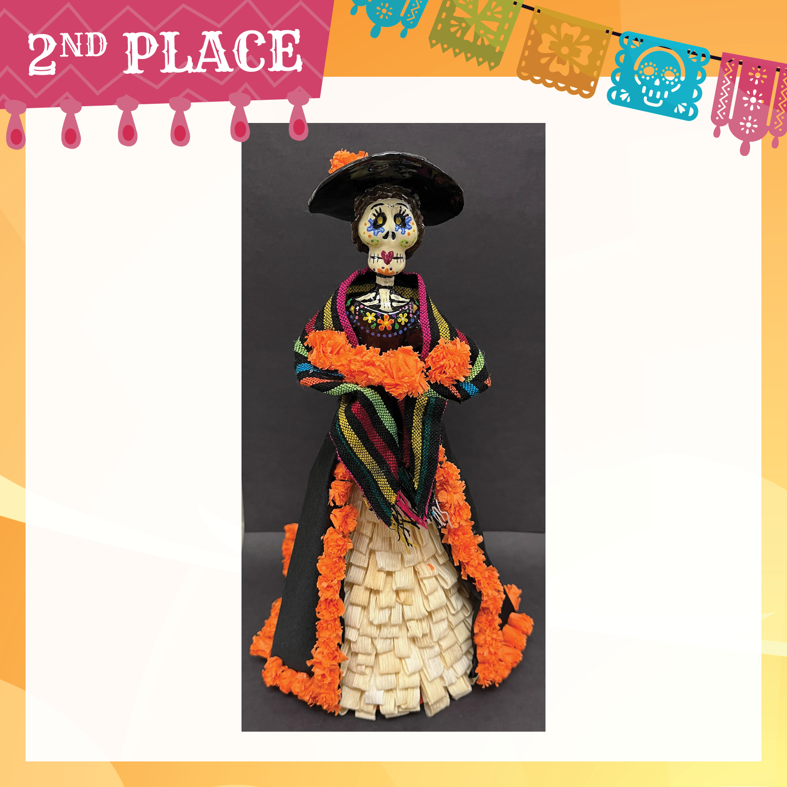 Dia de los muertos sculpture wearing a colorful dress with cornhusk skirt adored with orange flowers