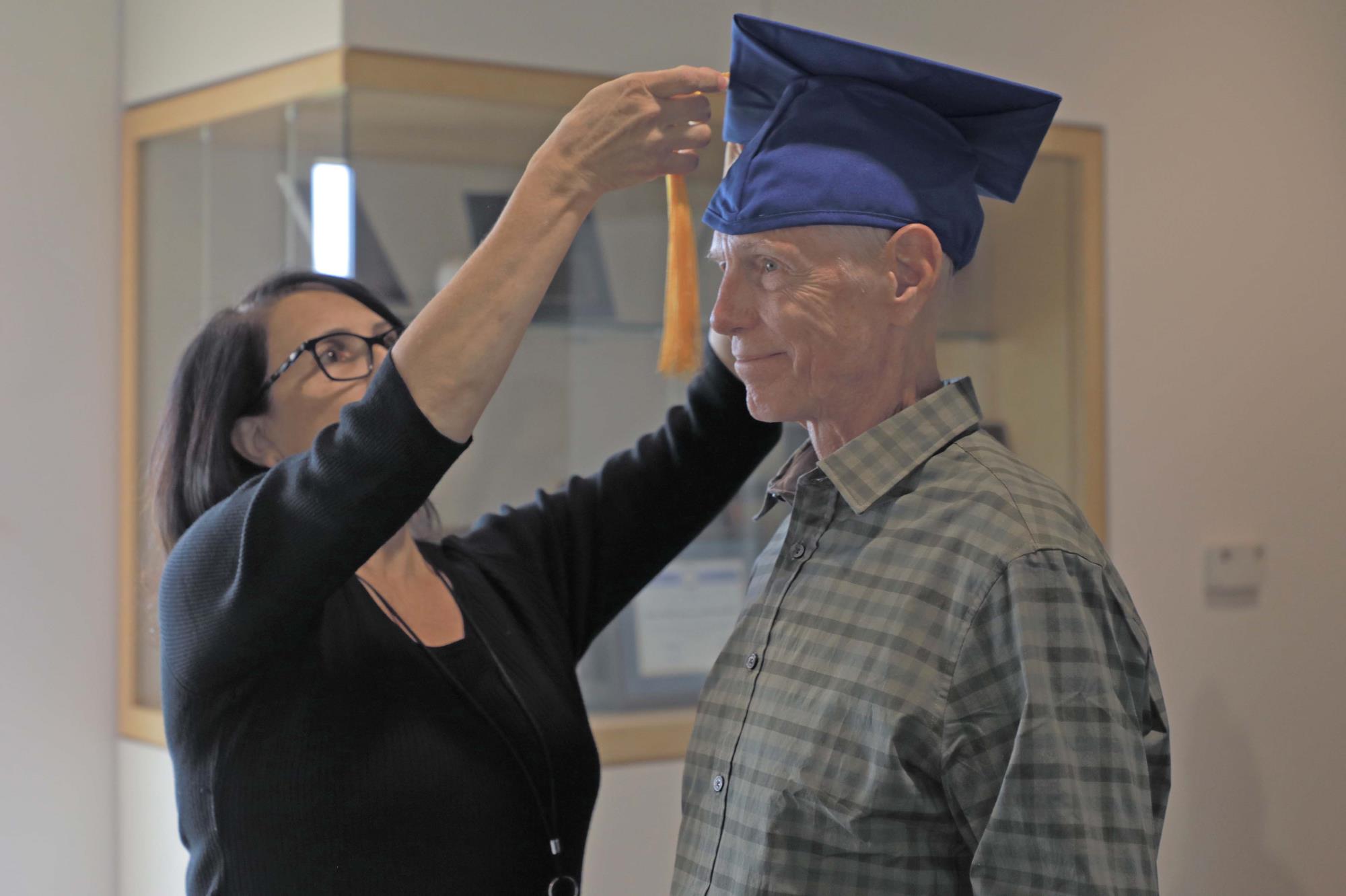 Veteran George Flowers gets help with graduation cap